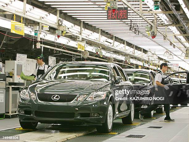 Workers at Japan's auto giant Toyota motor inspect newly assembled LEXUS cars at the company's Tahara plant in Aichi prefecture, 28 June 2007. 670...