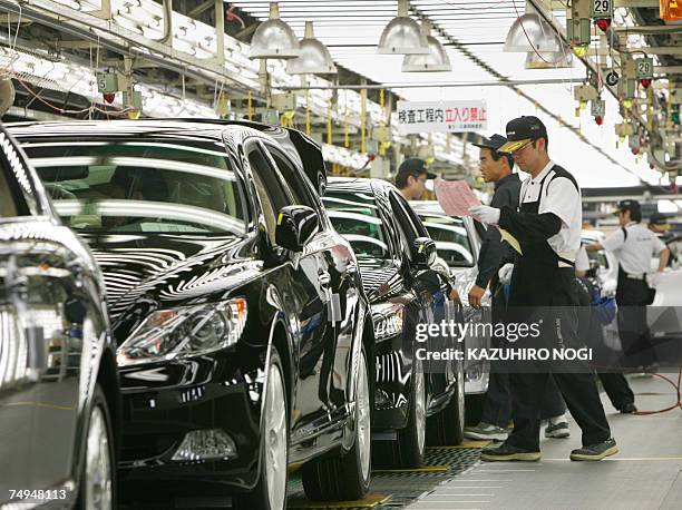 Workers at Japan's auto giant Toyota motor inspect newly assembled LEXUS cars at the company's Tahara plant in Aichi prefecture, 28 June 2007. 670...