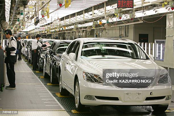 Workers at Japan's auto giant Toyota motor inspect newly assembled LEXUS cars at the company's Tahara plant in Aichi prefecture, 28 June 2007. 670...