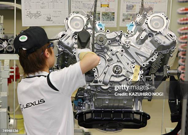 Worker at Japan's auto giant Toyota motor assembles an engine for LEXUS cars at the company's Tahara plant in Aichi prefecture, 28 June 2007. 670...