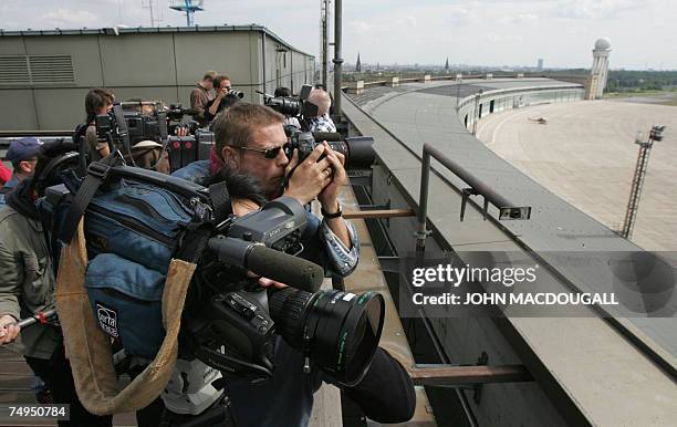 Cameramen shoot footage from the roof of Tempelhof airport's main terminal in Berlin 29 June 2007. Tempelhof airport is expected to cease all flight...