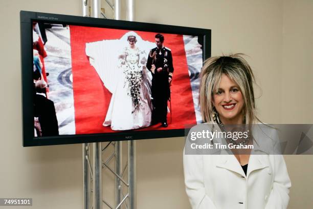 Fashion designer Elizabeth Emanuel, who designed dresses for Diana, Princess of Wales, stands in front of a screen showing the wedding dress she and...