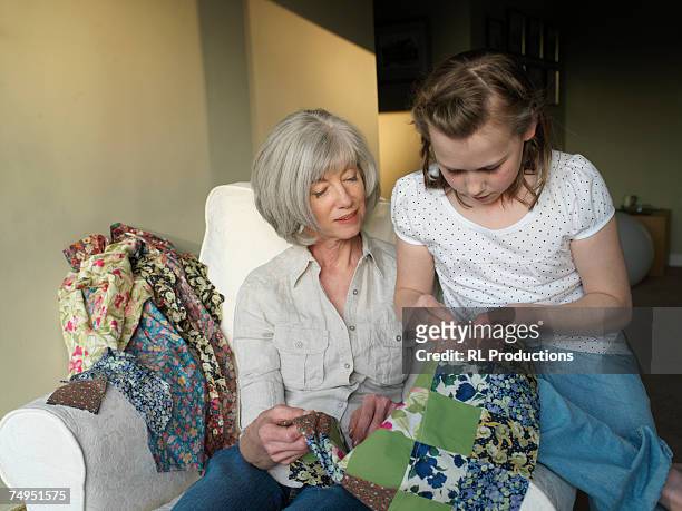 grandmother and granddaughter (9-11) sewing quilt - edredom - fotografias e filmes do acervo