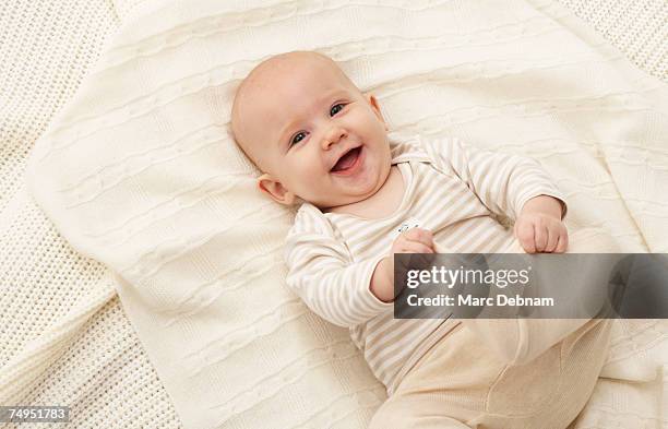 baby girl (3-6 months) lying on blanket, smiling - baby 3 months stock-fotos und bilder