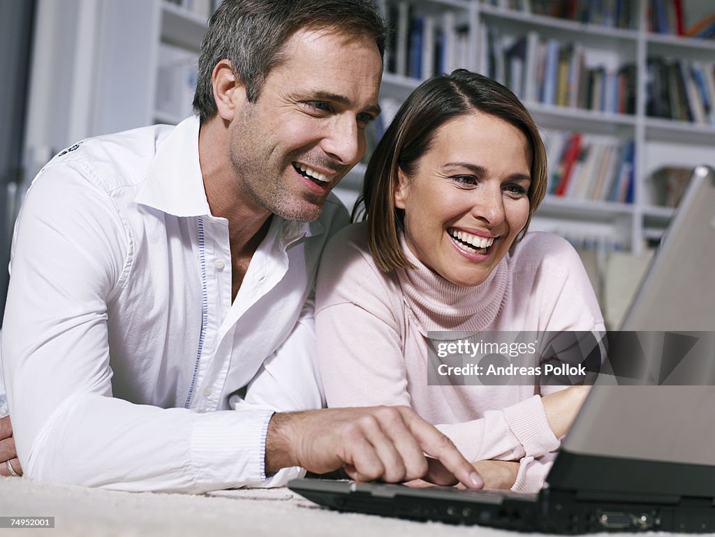 Smiling Mid Adult Couple Using Laptop Computer