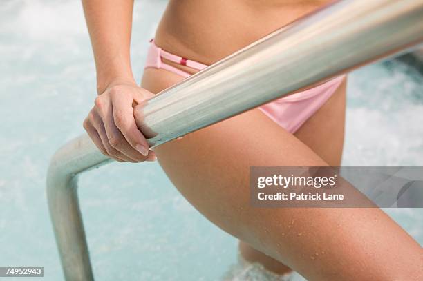 woman stepping out of hot tub - rising damp stock pictures, royalty-free photos & images