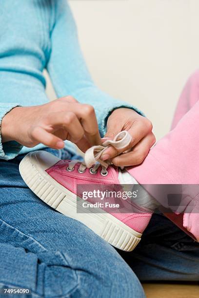girl tying shoelaces - fingertier stock pictures, royalty-free photos & images