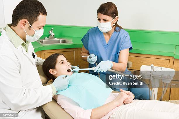 dentists cleaning girl's teeth - dental hygiene counter stock pictures, royalty-free photos & images