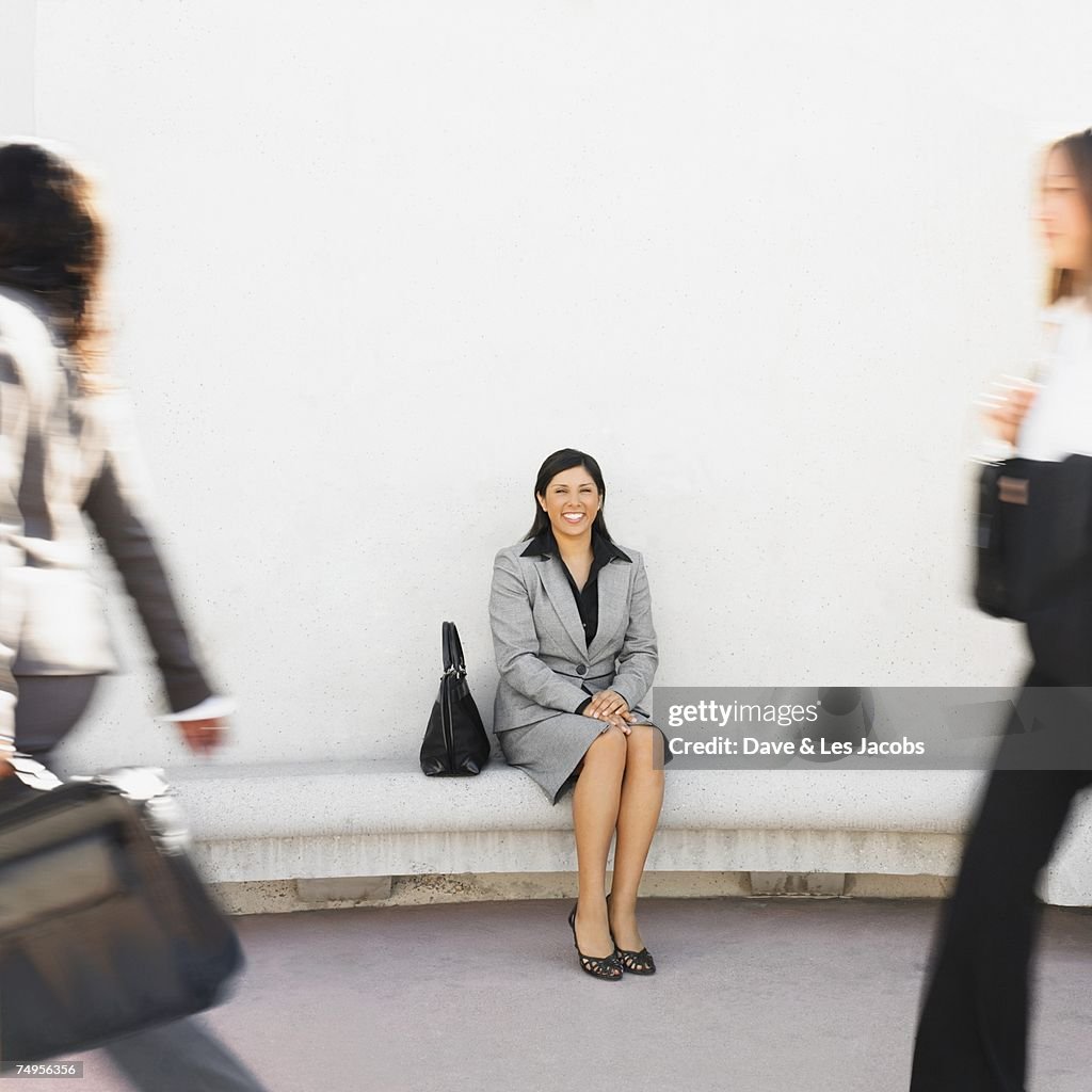 Hispanic businesswoman sitting outdoors