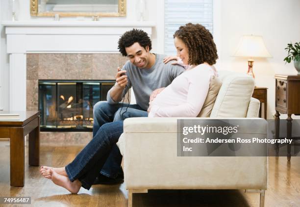 african man holding stopwatch next to pregnant wife - muscular contraction stock pictures, royalty-free photos & images