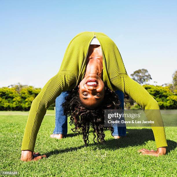 african woman doing back bend in grass - head back stock pictures, royalty-free photos & images