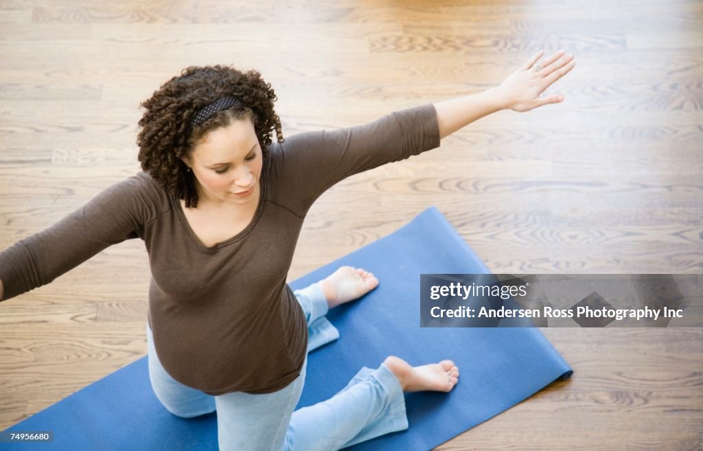 Pregnant African woman practicing yoga