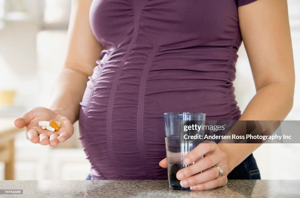 Pregnant African woman taking vitamins