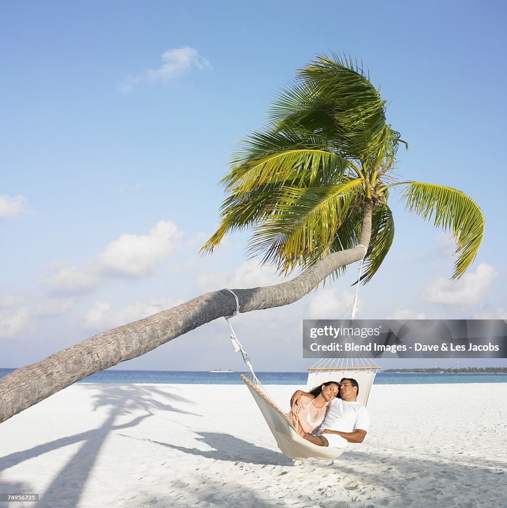 Hispanic couple in hammock at beach