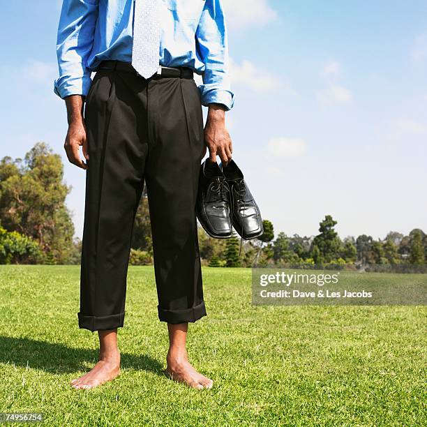 african businessman with bare feet in field - barefoot black men stock pictures, royalty-free photos & images