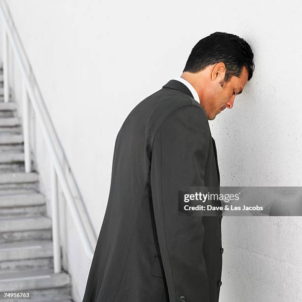 hispanic businessman leaning head on wall - misstag bildbanksfoton och bilder