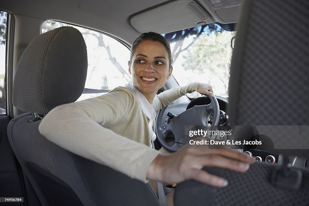 Hispanic woman backing up car