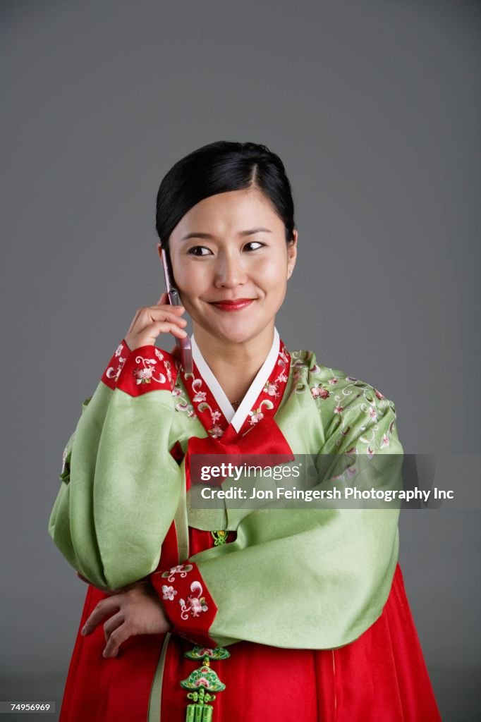 Korean woman in traditional dress talking on cell phone