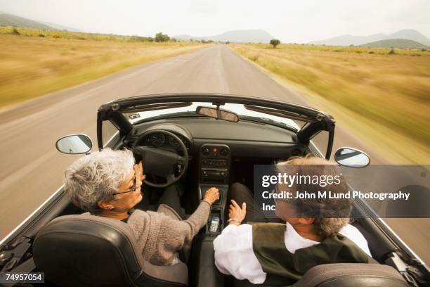 senior multi-ethnic couple driving convertible car - ethnic woman driving a car stock pictures, royalty-free photos & images