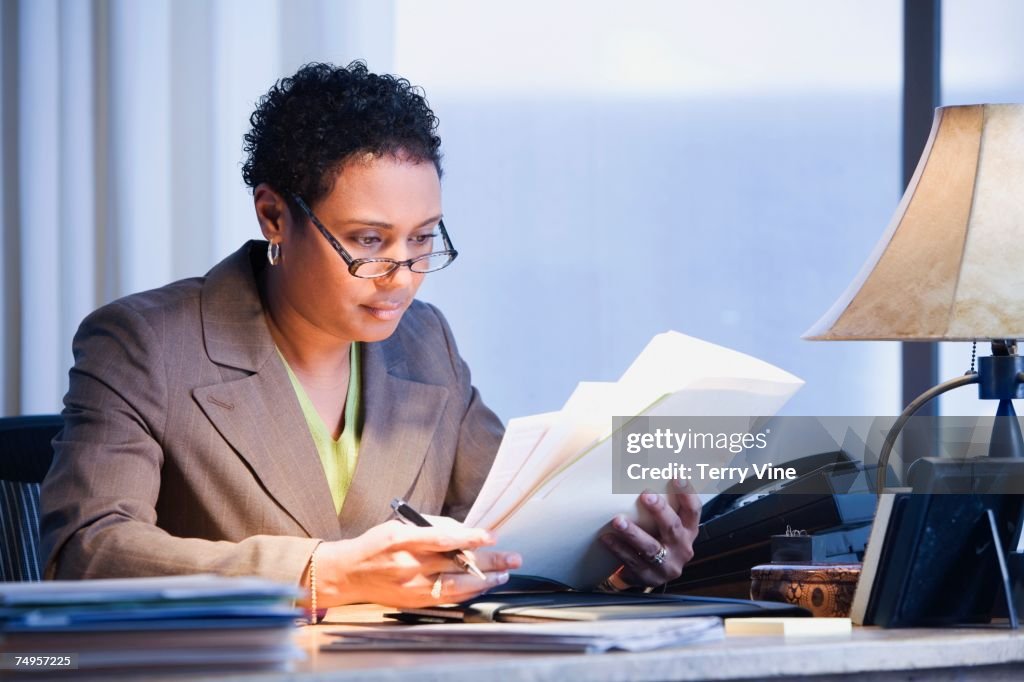 African businesswoman reading paperwork