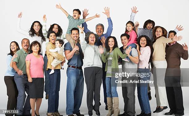 multi-generational hispanic family jumping and waving - large family ストックフォトと画像