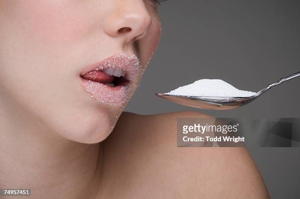 woman eating spoon of sugar - women licking women stock pictures, royalty-free photos & images