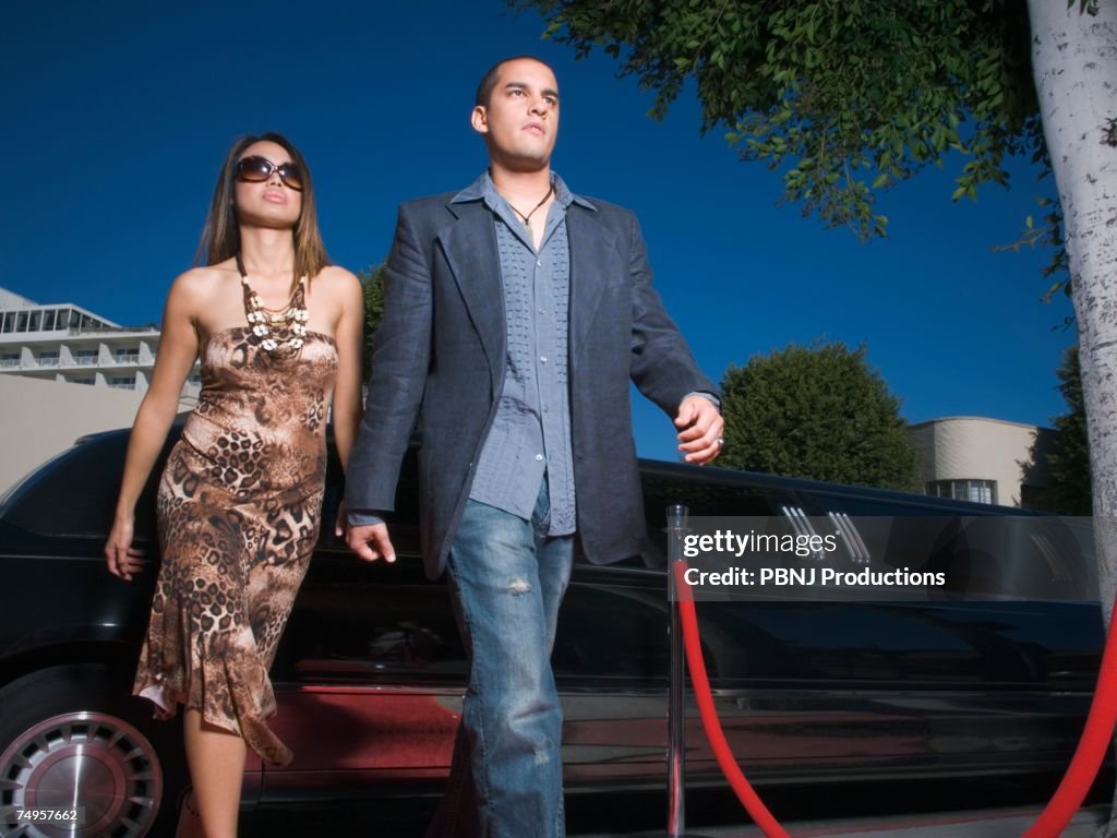 Multi-ethnic couple walking away from limousine