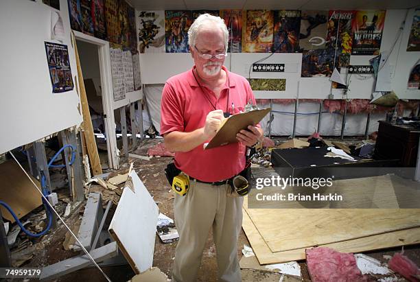 Dave Kocher, an insurance claims adjuster with National Flood, surveys the damage at Game Day Cards and Comics June 29, 2007 in Marble Falls, Texas....