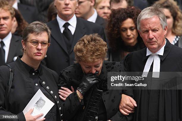 Widow Sabine Wussow is accompanied by priest Juergen Fliege at the funeral service for the late German actor Klausjuergen Wussow at the Kaiser...