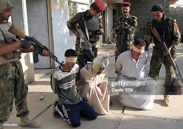 Iraqi soldiers guard blindfolded suspects at a military detention centre in the restive city of Baquba, in Diyala province, northeast of Baghdad, 30...