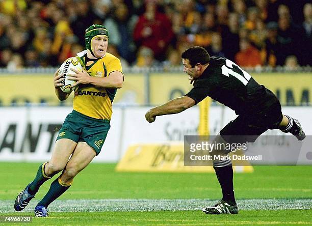Matt Giteau of the Wallabies evades the outstretched hand on Luke McAlister of the All Blacks during the 2007 Tri Nations match between Australia and...