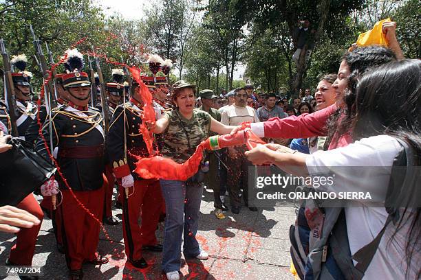 Familiares de victimas de la guerra lanzan pintura roja a soldados del Ejercito de Guatemala que con un desfile conmemoran el 136 aniversario de su...