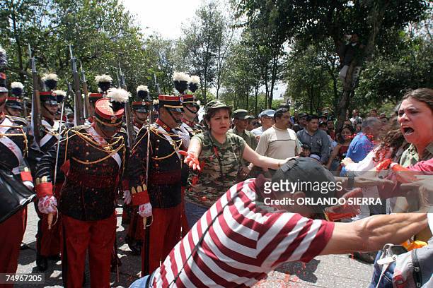 Familiares de victimas de la guerra lanzan pintura roja a soldados del Ejercito de Guatemala que con un desfile conmemoran el 136 aniversario de su...