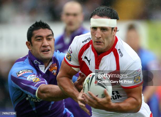 Lee Gilmour of St Helens is tackled by Jamahl Lolesi of Huddersfield Giants during the Engage Super League match between St Helens and Huddersfield...