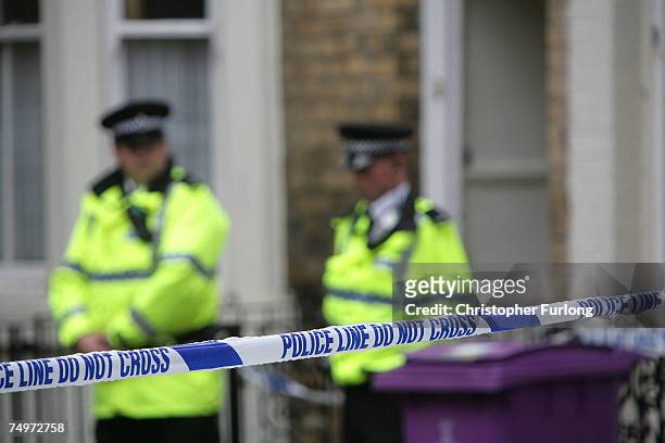 Police officers stand outside a house in Hatherley Street, after a raid searching for terror suspects on July 1, 2007 in Liverpool, England. Police...