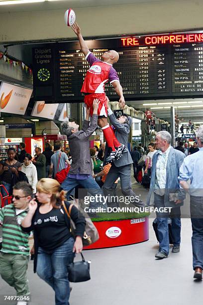 Des personnes passent devant une statue representant un joueur de rugby, le 01 juillet 2007 a la gare Montparnasse a Paris, a quelques semaines du...