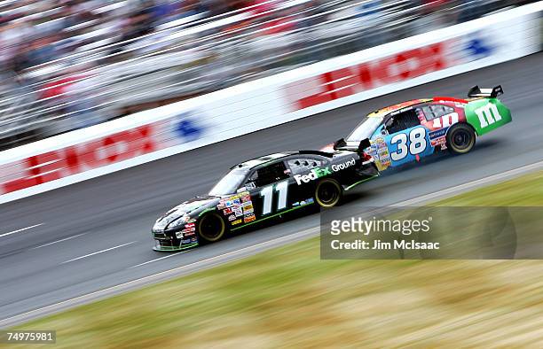 Denny Hamlin, driver of the FedEx Ground Chevrolet, leads David Gilliland, driver of the M & M's Ford, during the NASCAR Nextel Cup Series Lenox...