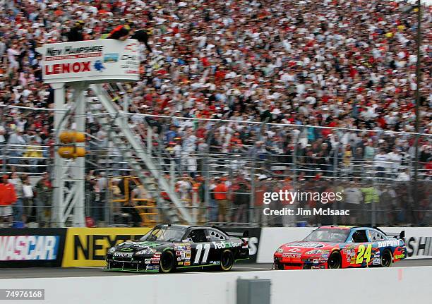 Denny Hamlin, driver of the FedEx Ground Chevrolet, crosses the finish line ahead of Jeff Gordon, driver of the DuPont Chevrolet, to win the NASCAR...