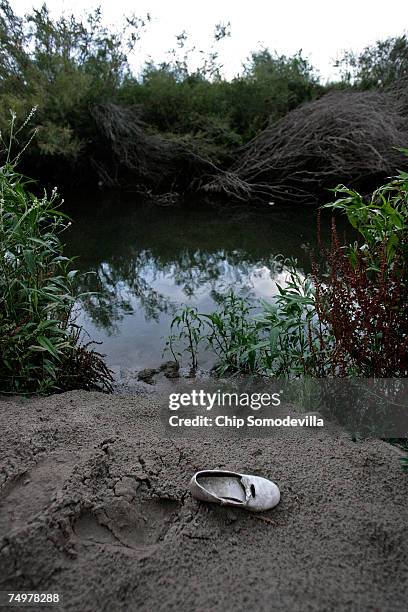 Child's shoe sits discarded on the Mexico side of the Rio Grande July 1, 2007 near Ciudad Juarez, Mexico. This area is a popular place for people to...