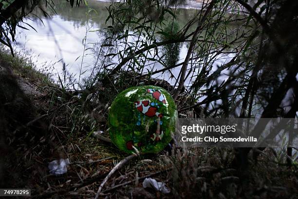 An inflatable beachball sits discarded on the southern bank of the Rio Grande July 1, 2007 near Ciudad Juarez, Mexico. This area is a popular place...