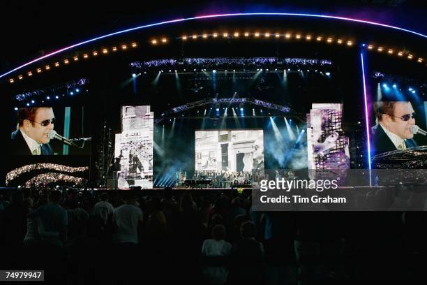 Fans of Diana, Princess of Wales watch Sir Elton John performing on stage at the 'Concert for Diana' at Wembley Stadium which the Princes organised...