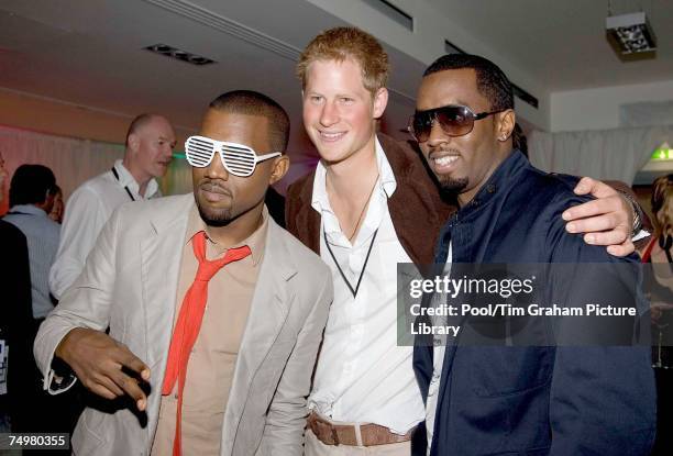 Prince Harry poses for a photograph with P Diddy and Kanye West at the after concert party the Princes hosted to thank all who took part in the...