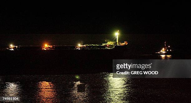 The massive coal carrier Pasha Bulker is towed out to sea by a tug boat from a beach in Newcastle, New South Wales, late 02 July 2007 after an...