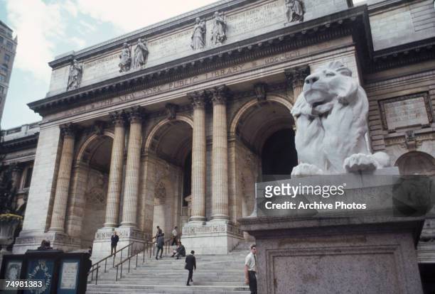 Stone lion guards the New York Public Library in New York City, October 1969. The library was formed in 1895 by the amalgamation of the Lenox Library...