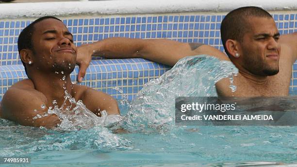Puerto La Cruz, VENEZUELA: Brazil's footballers Robinho and Daniel Alves enjoy the swimming pool after a training session in Puerto La Cruz,...