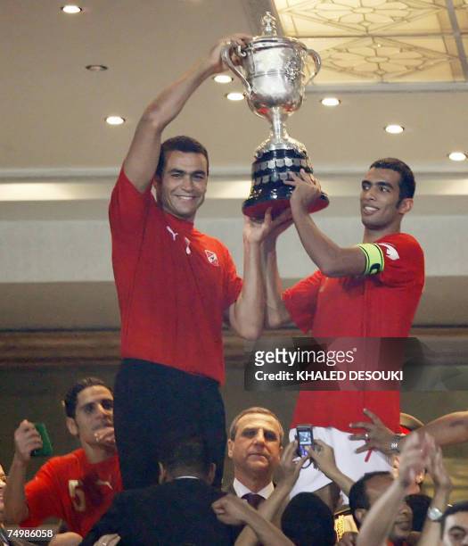 Egyptian captain of al-Ahly football team Shadi Mohamed and his teammate goalkeeper Issam el-Hadari hoist the cup after their victory vs Zamalek club...