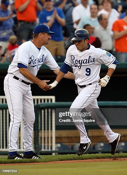 David DeJesus of the Kansas City Royals is congratulated by third base coach Brian Poldberg after hitting a home run during the fourth inning of the...