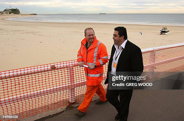 New South Wales Ports Minister Joe Tripodi and Salvage Master Drew Shannon inspect Nobby's Beach in Newcastle, north of Sydney, 03 July 2007. The...