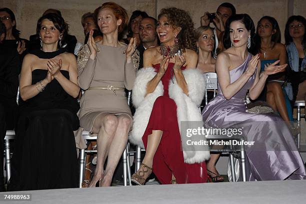 Actresses Juliette Binoche, Tilda Swinton, Marisa Berenson and burlesque performer and model Dita von Teese watch from front row seats the Christian...