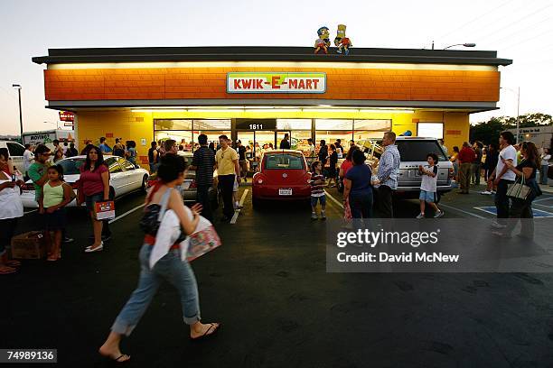 People gather around a 7-11 convenience store converted into a "Kwik-E-Mart" store from the long-running television cartoon show "The Simpsons" to...